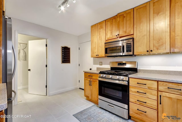 3941 Eric Cir, Anchorage, AK 99507 - kitchen featuring appliances with stainless steel finishes, track lighting, and light tile patterned floors