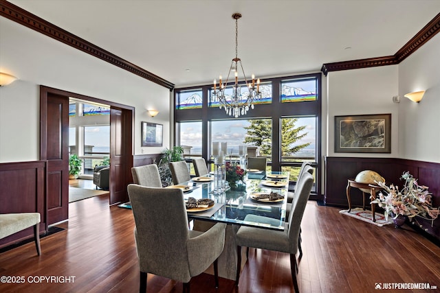 9900 Hillhaven Cir, Anchorage, AK 99507 - dining space featuring a chandelier, ornamental molding, plenty of natural light, a wainscoted wall, and dark wood-type flooring