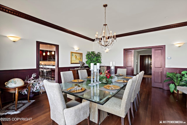 9900 Hillhaven Cir, Anchorage, AK 99507 - dining room featuring a wainscoted wall, crown molding, a chandelier, dark wood-type flooring, and a decorative wall