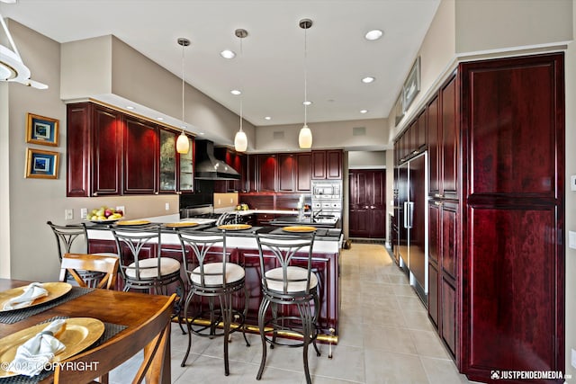 9900 Hillhaven Cir, Anchorage, AK 99507 - kitchen with reddish brown cabinets, built in appliances, wall chimney exhaust hood, light tile patterned floors, and recessed lighting