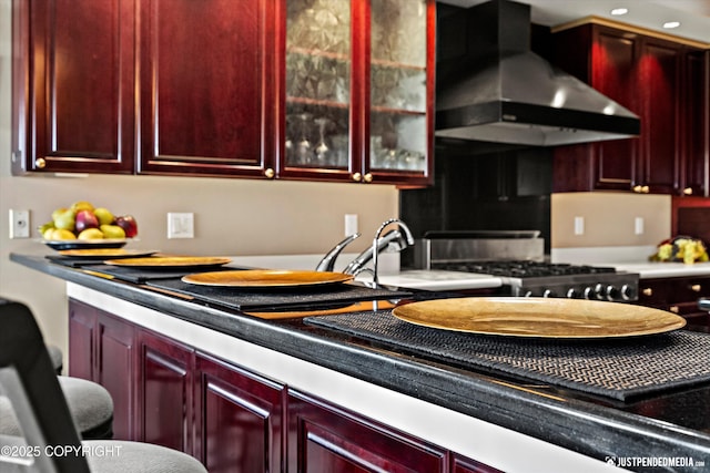 9900 Hillhaven Cir, Anchorage, AK 99507 - kitchen featuring reddish brown cabinets, wall chimney exhaust hood, range with gas cooktop, and glass insert cabinets