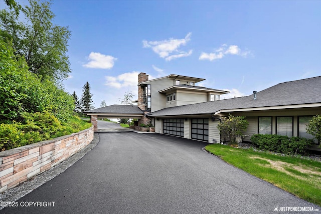 9900 Hillhaven Cir, Anchorage, AK 99507 - view of front of house featuring a chimney, driveway, and an attached garage