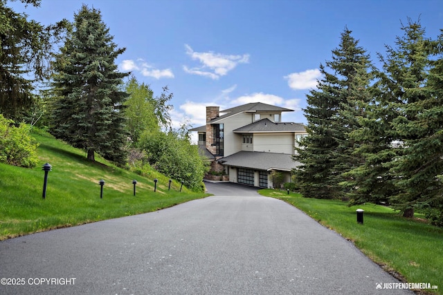 9900 Hillhaven Cir, Anchorage, AK 99507 - view of front of home with a garage, a front yard, a chimney, and driveway