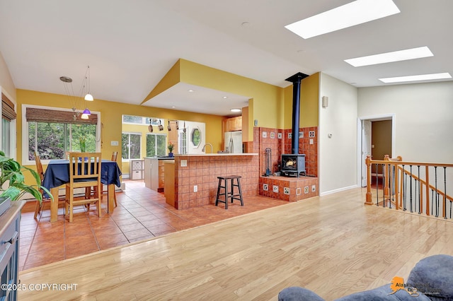 3868 Shannon Cir, Anchorage, AK 99508 - living room with a wood stove, light wood finished floors, a skylight, and vaulted ceiling