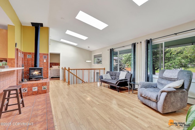 3868 Shannon Cir, Anchorage, AK 99508 - sitting room featuring vaulted ceiling, a wood stove, a skylight, light wood-type flooring, and baseboard heating