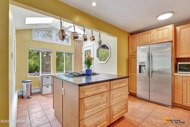 3868 Shannon Cir, Anchorage, AK 99508 - kitchen with stainless steel appliances, light brown cabinets, light tile patterned floors, a skylight, and vaulted ceiling