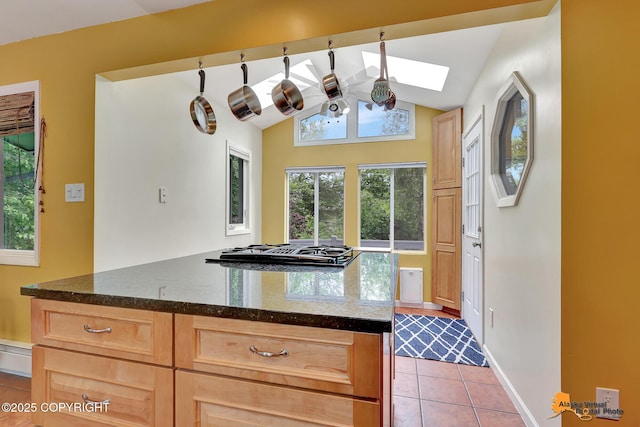 3868 Shannon Cir, Anchorage, AK 99508 - kitchen featuring gas cooktop, light tile patterned floors, light brown cabinets, vaulted ceiling, and plenty of natural light