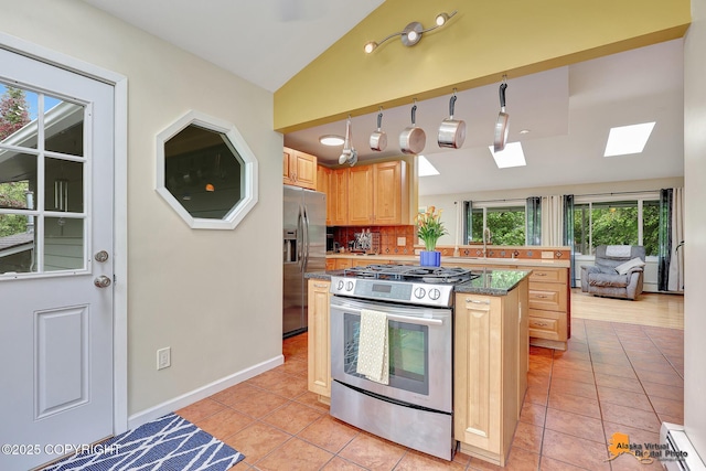3868 Shannon Cir, Anchorage, AK 99508 - kitchen featuring stainless steel appliances, lofted ceiling, light tile patterned flooring, a kitchen island, and a skylight