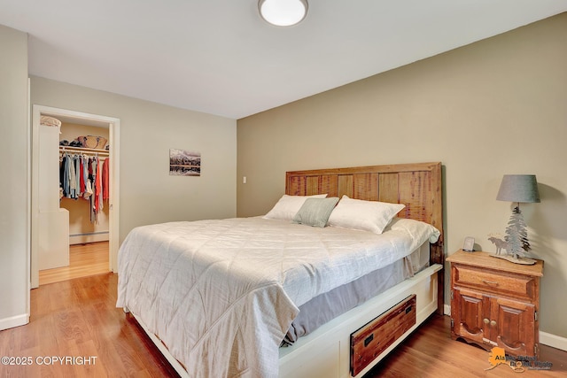 3868 Shannon Cir, Anchorage, AK 99508 - bedroom featuring wood finished floors, baseboard heating, a walk in closet, and baseboards