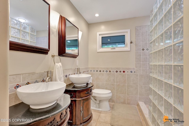 3868 Shannon Cir, Anchorage, AK 99508 - full bath with tile walls, double vanity, walk in shower, tile patterned flooring, and wainscoting