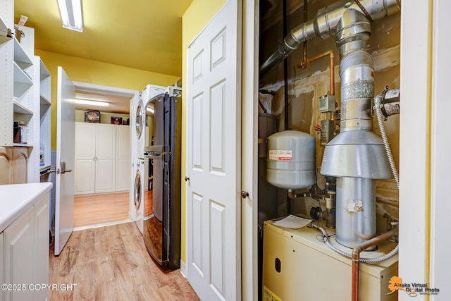 3868 Shannon Cir, Anchorage, AK 99508 - washroom featuring estacked washer and dryer, light wood-style flooring, and cabinet space