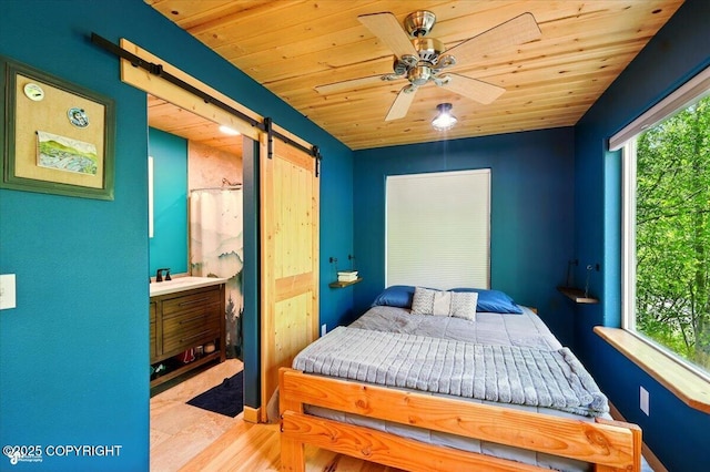 23069 Christiansen Lake Rd, Talkeetna, AK 99676 - bedroom with a barn door, wooden ceiling, and ceiling fan