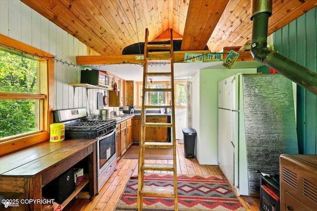 23069 Christiansen Lake Rd, Talkeetna, AK 99676 - kitchen featuring stainless steel gas range oven, vaulted ceiling, wood ceiling, light wood-style flooring, and wooden walls
