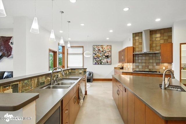10500 Blackwolf Cir, Anchorage, AK 99507 - kitchen with wall chimney exhaust hood, a large island with sink, recessed lighting, backsplash, and brown cabinetry