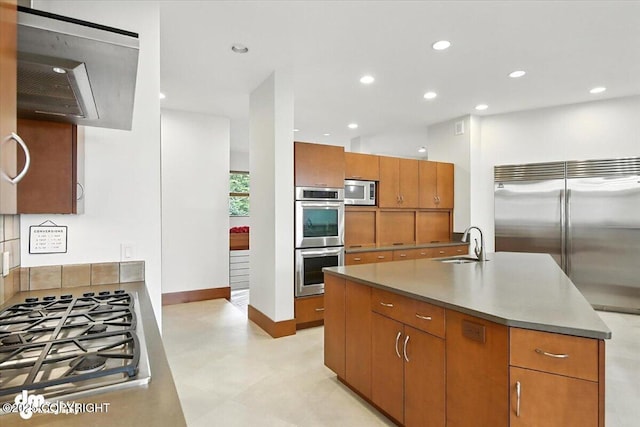 10500 Blackwolf Cir, Anchorage, AK 99507 - kitchen featuring built in appliances, brown cabinetry, recessed lighting, and an island with sink