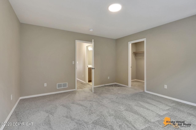20290 Eagles Nest Ct, Eagle River, AK 99577 - unfurnished bedroom featuring carpet, baseboards, and a walk in closet