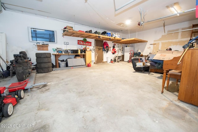4530 Macalister Dr, Anchorage, AK 99502 - garage featuring freestanding refrigerator, a workshop area, and a garage door opener