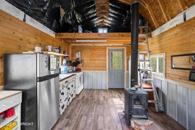 6360 Haystack Dr, Fairbanks, AK 99712 - kitchen with a wood stove, freestanding refrigerator, white range with gas stovetop, wood walls, and wood finished floors