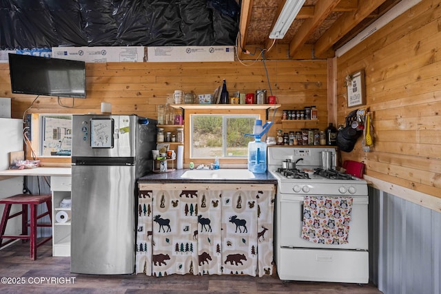 6360 Haystack Dr, Fairbanks, AK 99712 - kitchen with white range with gas stovetop, freestanding refrigerator, wood walls, wood finished floors, and a sink