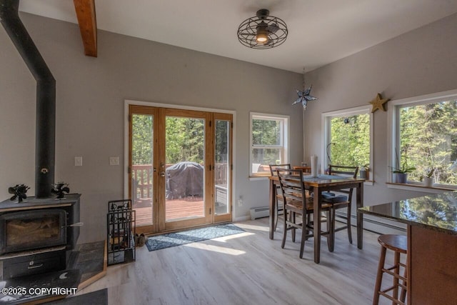 33426 Mid River Ave, Soldotna, AK 99669 - dining room with wood finished floors, a wood stove, a baseboard heating unit, and beam ceiling
