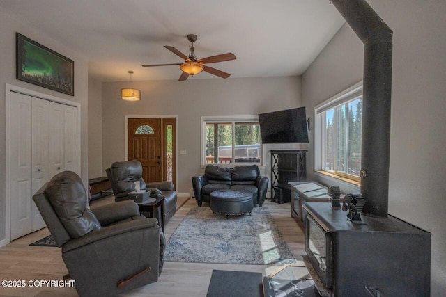 33426 Mid River Ave, Soldotna, AK 99669 - living room featuring light wood-style floors, a ceiling fan, and a wood stove