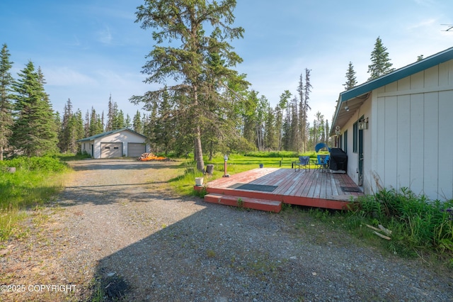 48160 Snowflake Ct, Soldotna, AK 99669 - view of yard featuring a deck, a detached garage, dirt driveway, and an outdoor structure