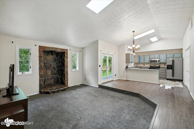 1940 E Caribou Loop, Wasilla, AK 99654 - unfurnished living room with a skylight, a chandelier, dark wood-type flooring, vaulted ceiling, and a textured ceiling