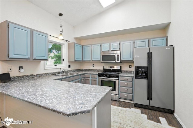 1940 E Caribou Loop, Wasilla, AK 99654 - kitchen featuring stainless steel appliances, lofted ceiling, a peninsula, dark wood finished floors, and pendant lighting