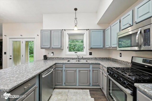 1940 E Caribou Loop, Wasilla, AK 99654 - kitchen featuring stainless steel appliances, gray cabinetry, a peninsula, dark wood-type flooring, and hanging light fixtures