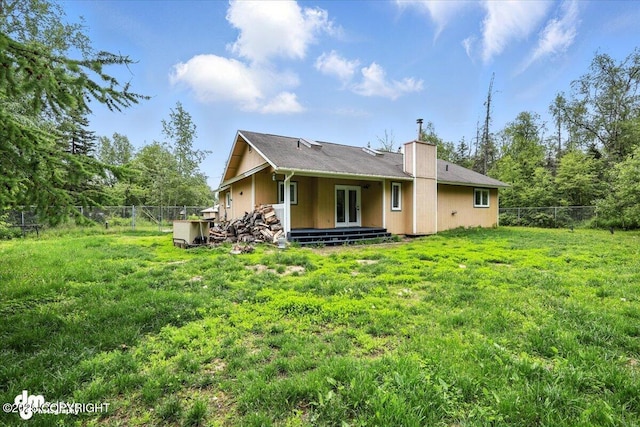 1940 E Caribou Loop, Wasilla, AK 99654 - back of house featuring french doors, a fenced backyard, and a chimney