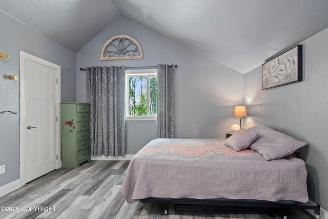 41167 Witman Ct, Soldotna, AK 99669 - bedroom featuring vaulted ceiling, wood finished floors, and baseboards
