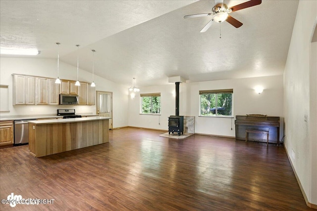 3963 N Coronado St, Wasilla, AK 99623 - kitchen featuring appliances with stainless steel finishes, open floor plan, a wood stove, vaulted ceiling, and light countertops