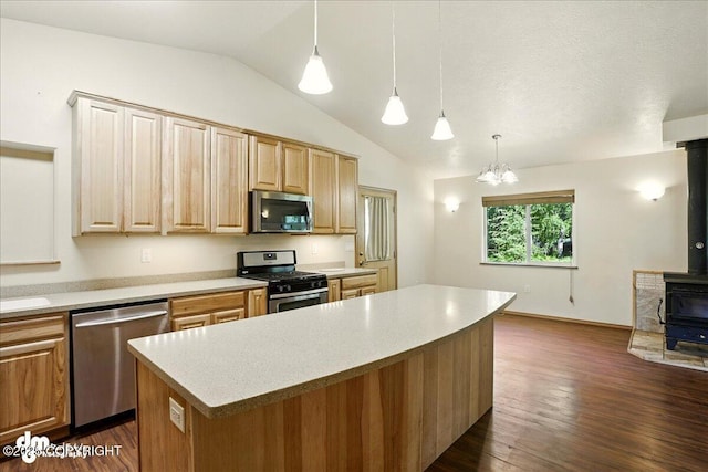 3963 N Coronado St, Wasilla, AK 99623 - kitchen featuring appliances with stainless steel finishes, lofted ceiling, a wood stove, light countertops, and a kitchen island