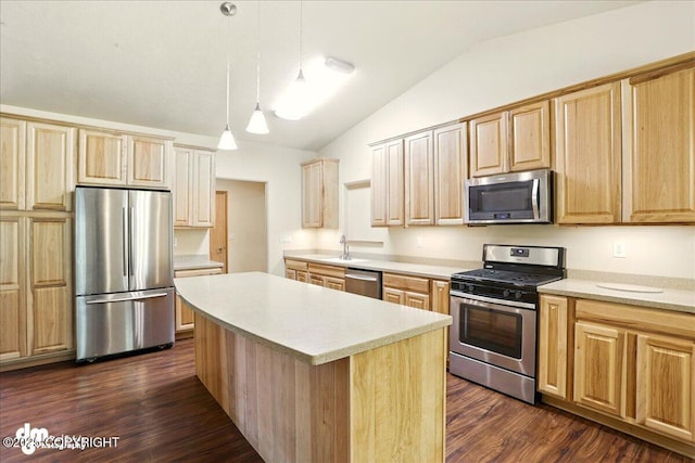 3963 N Coronado St, Wasilla, AK 99623 - kitchen with appliances with stainless steel finishes, vaulted ceiling, a kitchen island, light brown cabinetry, and light countertops