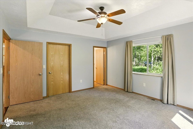 3963 N Coronado St, Wasilla, AK 99623 - unfurnished bedroom with carpet floors, a tray ceiling, and a ceiling fan