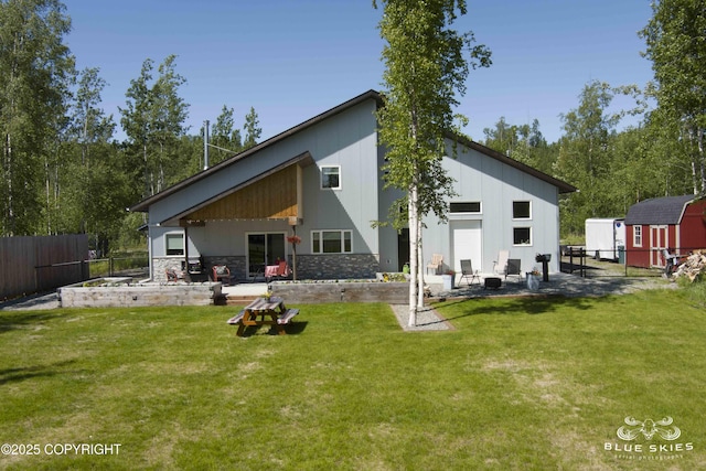6961 S Hangar Talk Cir, Wasilla, AK 99623 - back of house featuring a patio, a storage shed, and stone siding