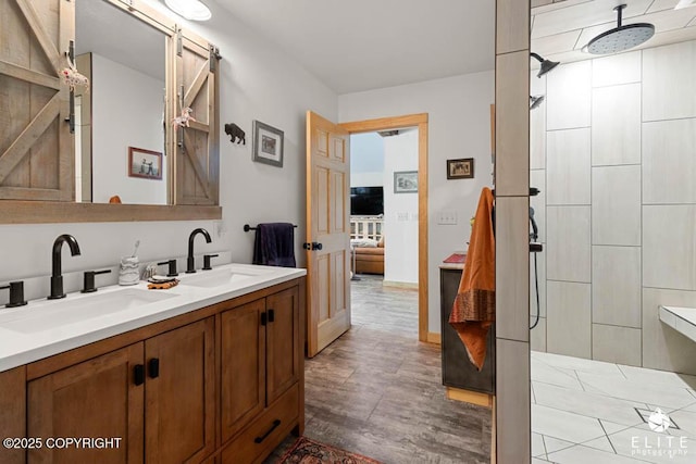 6961 S Hangar Talk Cir, Wasilla, AK 99623 - ensuite bathroom with double vanity, tiled shower, and wood finished floors