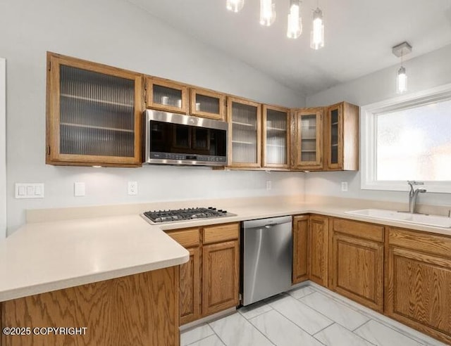 2551 Lahonda Dr, Anchorage, AK 99517 - kitchen with stainless steel appliances, a sink, brown cabinets, lofted ceiling, and light marble finish flooring