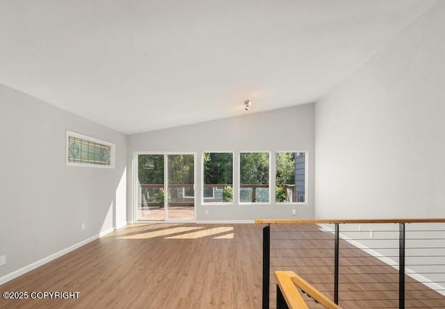2551 Lahonda Dr, Anchorage, AK 99517 - unfurnished living room featuring vaulted ceiling, wood finished floors, and baseboards