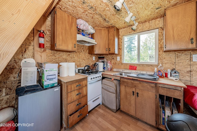 45638 Back Troll, Kenai, AK 99611 - kitchen featuring gas range gas stove, light countertops, light wood-style floors, under cabinet range hood, and brown cabinets