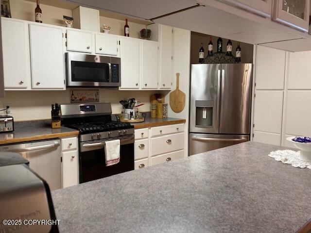 50470 Maranatha Ln, Nikiski/North Kenai, AK 99611 - kitchen featuring stainless steel appliances and white cabinetry