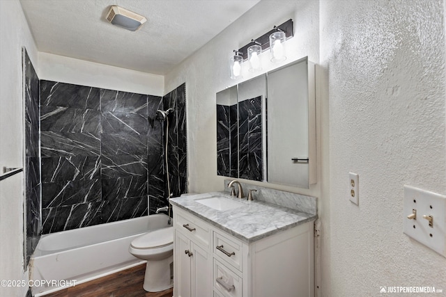 1711 Russian Jack Dr # B4, Anchorage, AK 99508 - bathroom with a textured wall, vanity, bathtub / shower combination, and wood finished floors