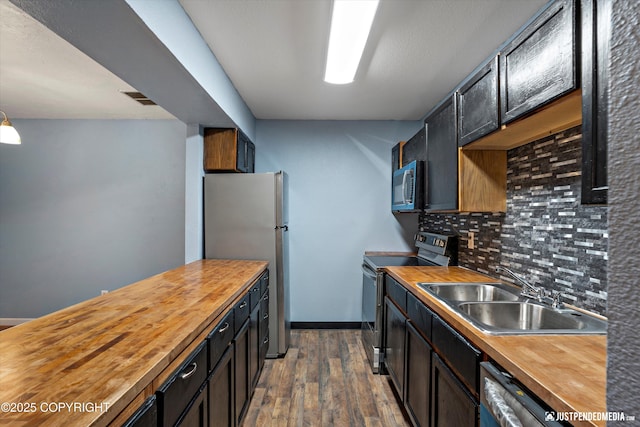 1711 Russian Jack Dr # B4, Anchorage, AK 99508 - kitchen featuring butcher block counters, range with electric stovetop, freestanding refrigerator, dishwashing machine, and backsplash