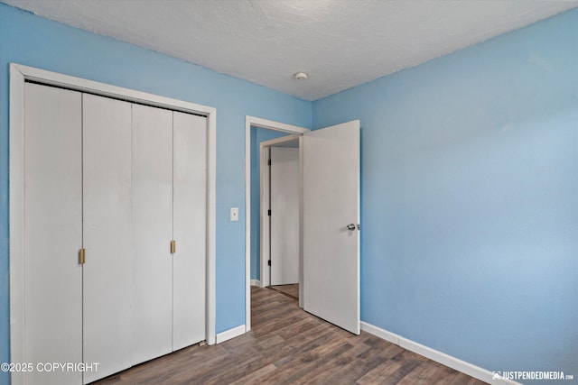 1711 Russian Jack Dr # B4, Anchorage, AK 99508 - unfurnished bedroom featuring dark wood-type flooring and a closet