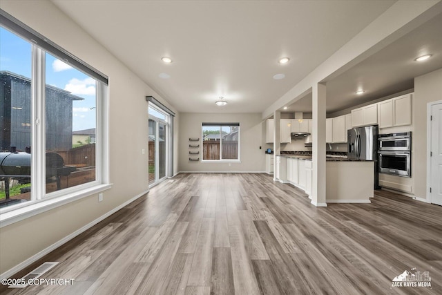 2987 Morgan Loop, Anchorage, AK 99516 - kitchen with open floor plan, stainless steel appliances, light wood-type flooring, white cabinetry, and under cabinet range hood