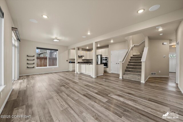 2987 Morgan Loop, Anchorage, AK 99516 - unfurnished living room with stairs, light wood-type flooring, and recessed lighting