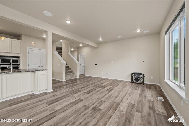 2987 Morgan Loop, Anchorage, AK 99516 - unfurnished living room with light wood-type flooring, stairway, and recessed lighting