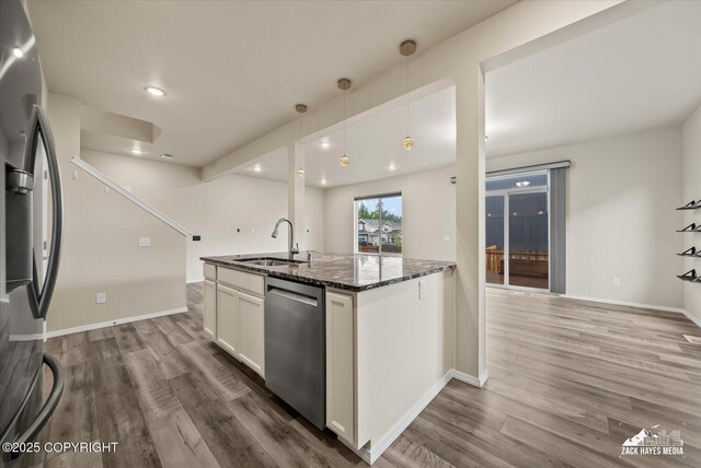 2987 Morgan Loop, Anchorage, AK 99516 - kitchen featuring appliances with stainless steel finishes, dark stone countertops, dark wood-style flooring, white cabinetry, and decorative light fixtures