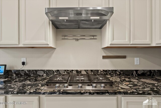 2987 Morgan Loop, Anchorage, AK 99516 - kitchen view of white cabinetry, under cabinet range hood, dark countertops, and stainless steel gas cooktop