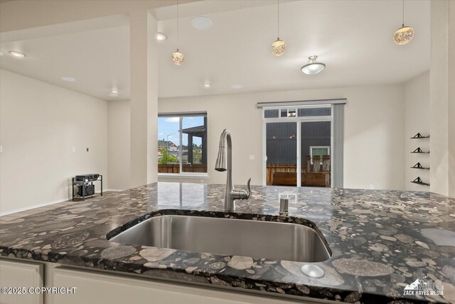 2987 Morgan Loop, Anchorage, AK 99516 - kitchen with dark stone counters, white cabinetry, and decorative light fixtures
